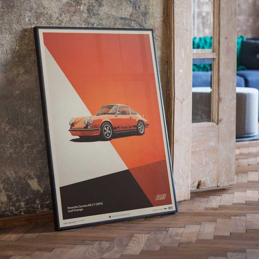 Affiche automobiliste encadrée Porsche 911 RS orange dans pièce avec parquet et mur en béton